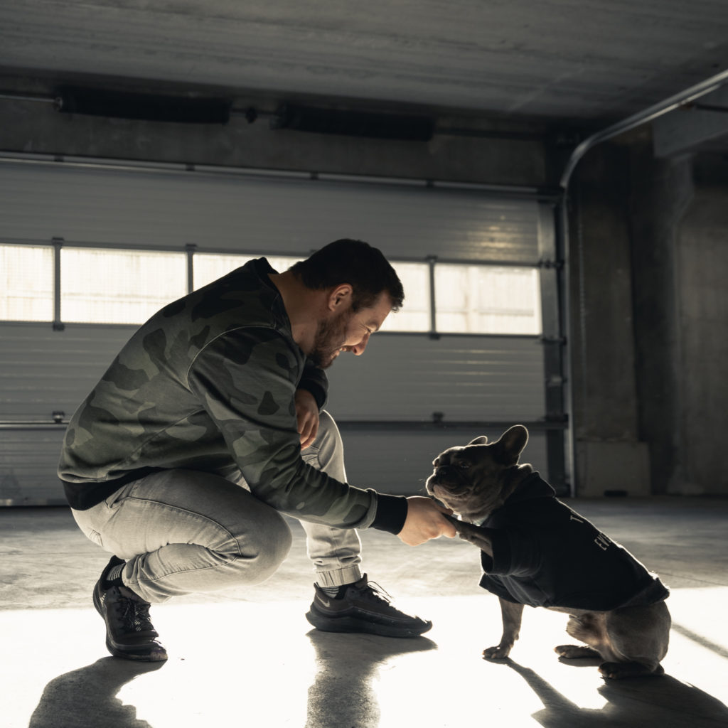 Peter and Füli in a packing garage, Peter is crouched down with his right hand out while Füli puts his left paw out for what peter called " props "